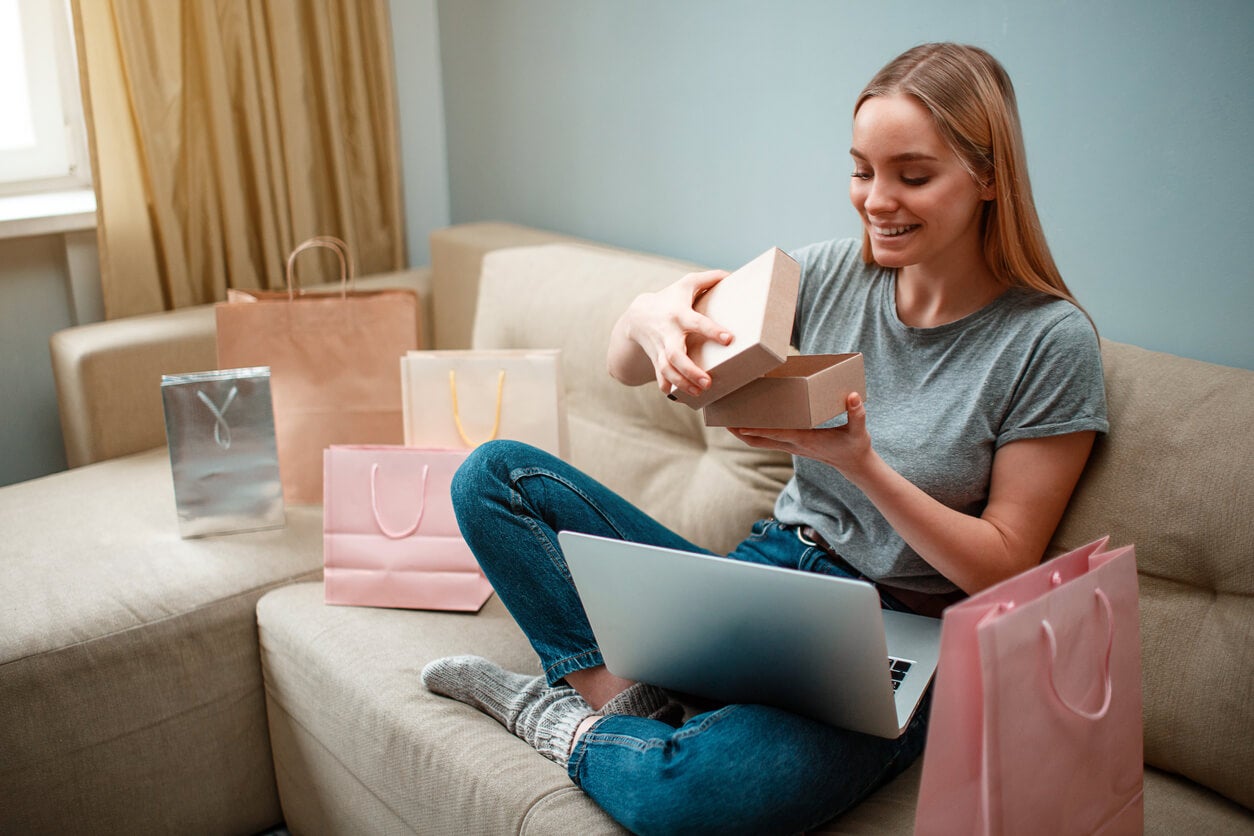 Mujer emocionada por compras pensando en ¿Por qué compro cosas que no necesito?