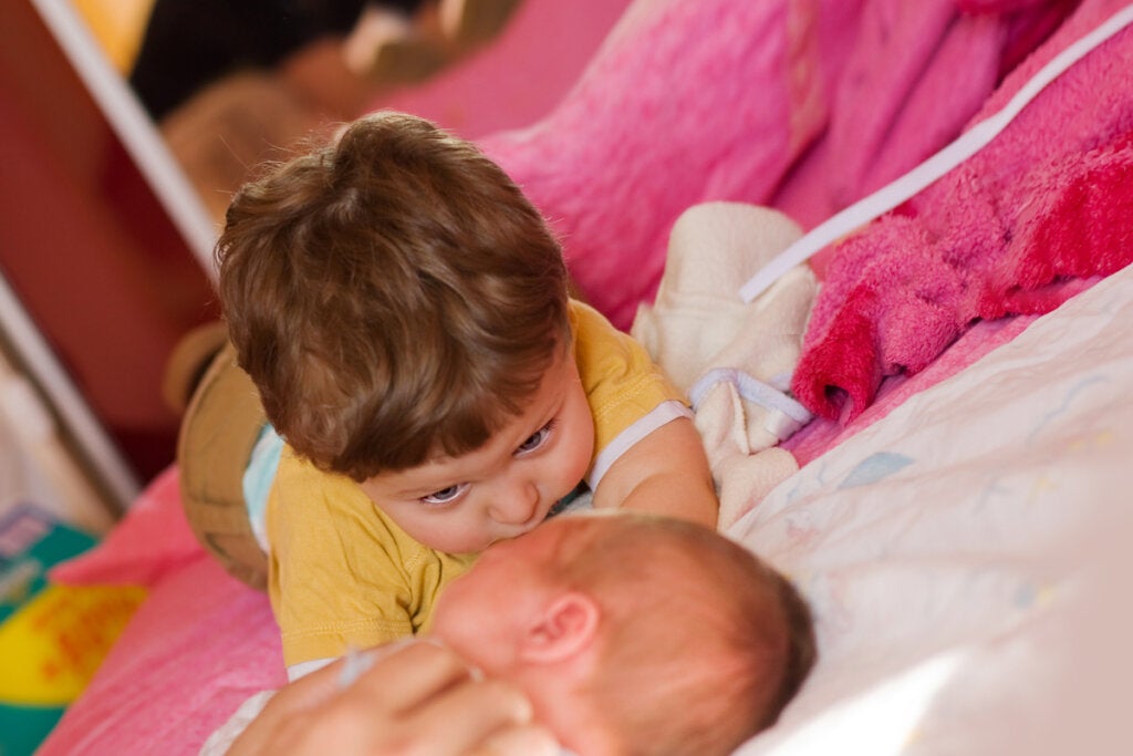 Abi bebek kardeşine bakıyor