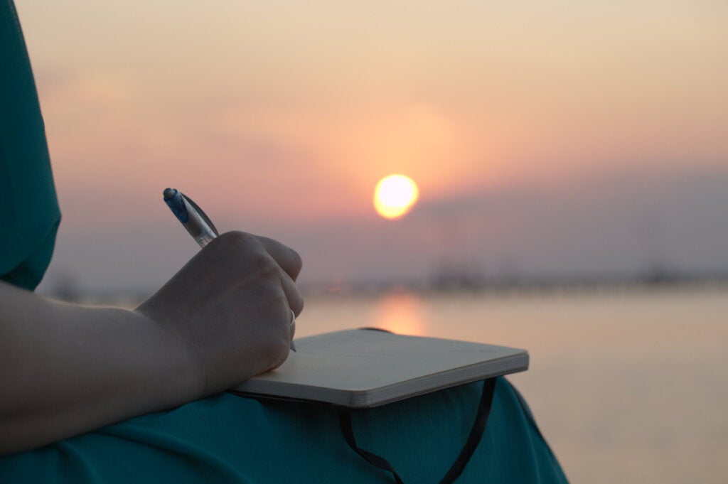 Gün batımında Mood Tracking Techniques'te yazan kadın